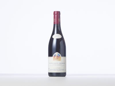 a bottle of red wine sitting on top of a white table