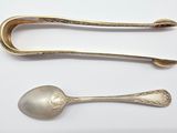 two silver spoons and a silver spoon on a white surface