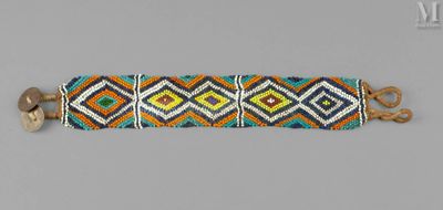 un gros plan d'un bracelet posé sur une surface grise