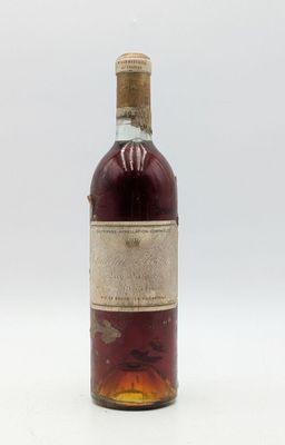 une vieille bouteille de vin posée sur une surface blanche
