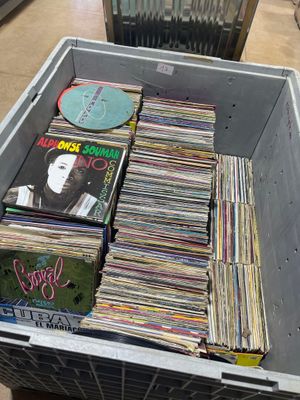 a lot of records in a box on the floor