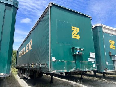 deux semi-remorques vertes garées sur le bord de la route