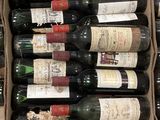 bottles of wine sit in a cardboard box on a table