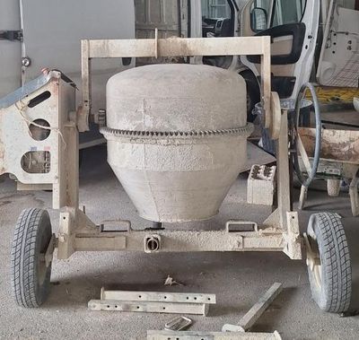 une bétonnière garée dans un garage à côté d'un camion