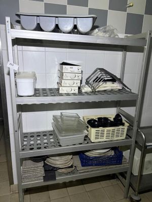 a metal shelf with dishes on it in a kitchen