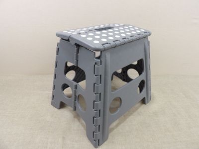 un tabouret gris à pois blancs