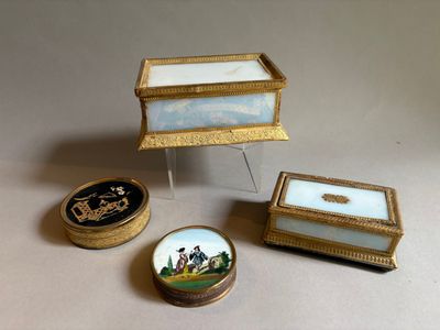 Trois boîtes miniatures sont posées les unes à côté des autres sur une table