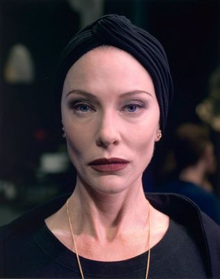 portrait of a woman with a turban on her head looking at the camera