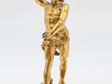 une figurine antique en bronze représentant un homme tenant une batte de baseball