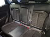 the back seats of a car are black and grey with red buttons