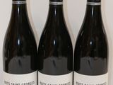 trois bouteilles de vin sont alignées sur une surface blanche