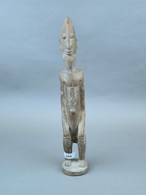 une vieille statue en bois d'un homme avec un chapeau sur la tête