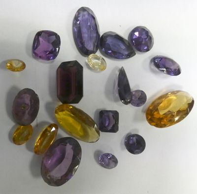 purple and yellow gems are arranged on a white surface