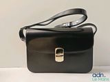 a small black bag with a gold buckle on it