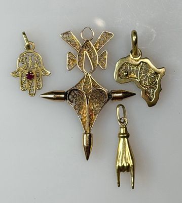 three gold and silver jewelry pieces are displayed on a white surface