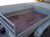 a truck with a bed full of chilis on the side of the road
