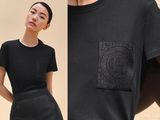 a woman wearing a black shirt and skirt with a black pocket
