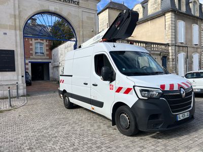 une camionnette blanche avec une bande rouge garée devant un immeuble
