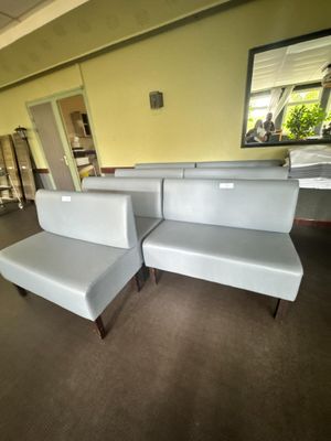 un canapé et un fauteuil dans une pièce où il y a un miroir accroché au mur