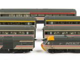 four model trains are lined up on a white surface