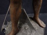 a bronze statue of a boy with a sword