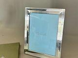 a green box and a silver picture frame on a table