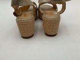 a close up of a pair of gold shoes on a white surface