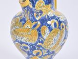a blue and yellow vase with a yellow handle on a white background