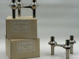 two silver candles that are sitting on top of a box