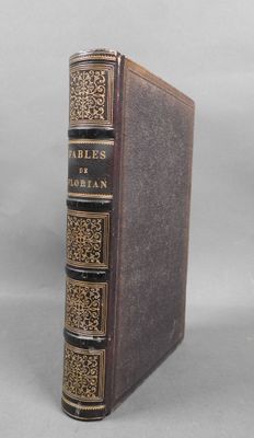an old book sitting on top of a table next to a white wall
