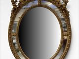 une image représentant un miroir au cadre doré accroché au mur