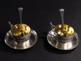 pair of silver plated tea cups and saucers with spoons