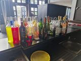 many bottles of alcohol sitting on a counter in the kitchen