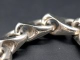 a close up of a silver bracelet on a black surface
