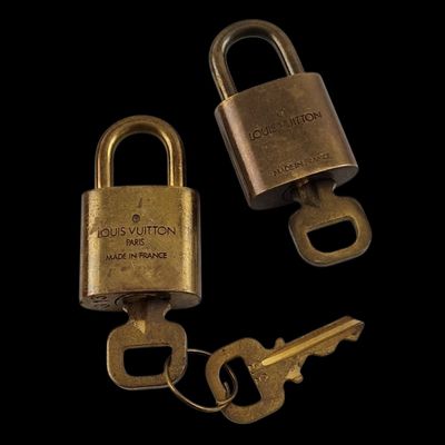 deux vieux cadenas en laiton et une clé sur fond noir