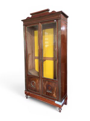 une vieille armoire en bois avec des portes vitrées et une porte jaune