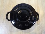 a black casserole sitting on a wooden table