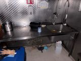 une cuisine avec un plan de travail en inox et une poubelle bleue