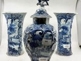 trois vases bleus et blancs posés sur une surface blanche