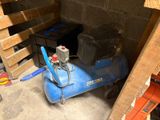 a blue air compressor sitting in the corner of a room