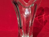 un vase en verre posé sur une surface rouge