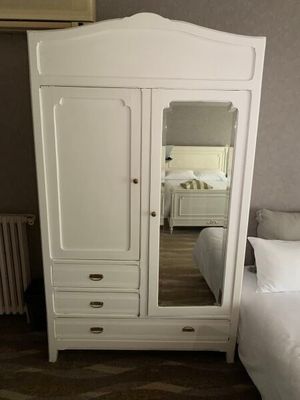 une photo d'une chambre à coucher avec un lit et une armoire blanche