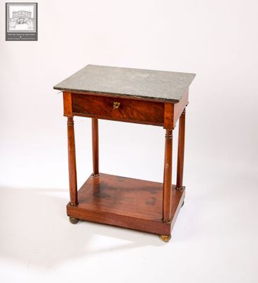 une petite table en bois avec un plateau en marbre, montée sur roulettes