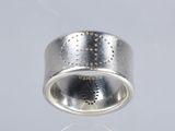 a close up of a silver ring with dots on it