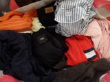 a suitcase full of clothes and a backpack on a bed