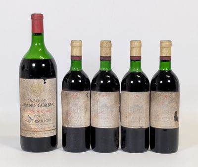 quatre bouteilles de vin sont alignées sur une surface blanche