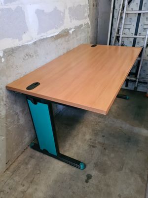 une table en bois avec un plateau bleu, dans un coin de la pièce