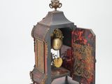 a clock that is sitting on a stand with a key in it