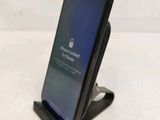 an image of a cell phone sitting on top of a wooden stand