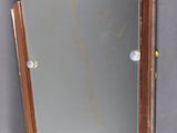 un miroir accroché au mur de la salle de bains